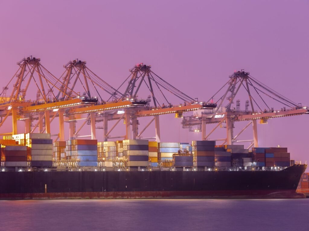 Gantry cranes loading a container ship at dusk